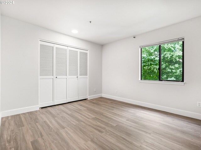 unfurnished bedroom featuring light hardwood / wood-style flooring and a closet