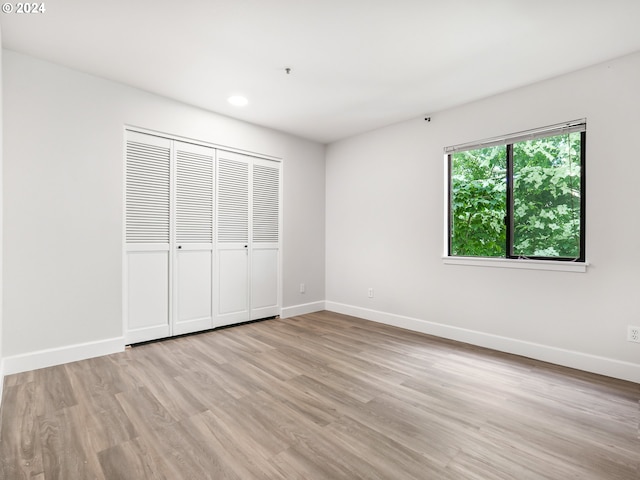 unfurnished bedroom with light hardwood / wood-style floors and a closet