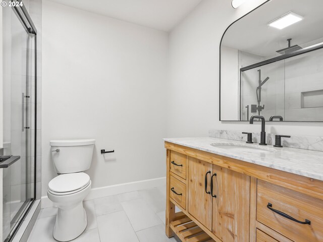 bathroom with tile patterned flooring, vanity, toilet, and a shower with door