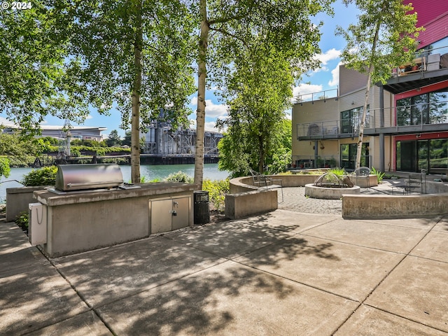 view of patio / terrace featuring a fire pit, area for grilling, a water view, and grilling area