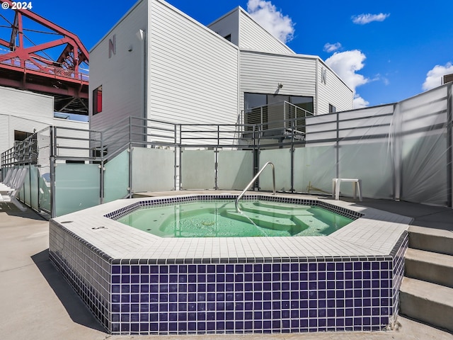 view of swimming pool featuring an in ground hot tub