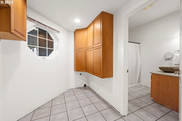 laundry room with cabinets, light tile patterned floors, and electric dryer hookup