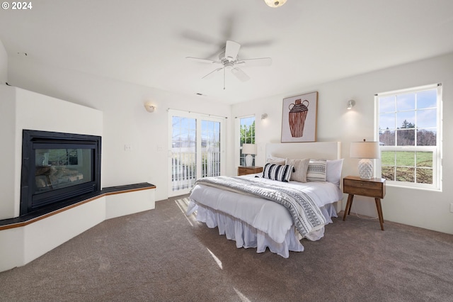 bedroom with access to exterior, ceiling fan, and dark carpet