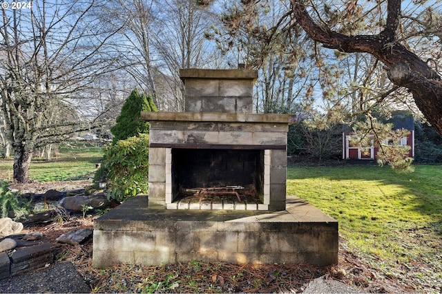 view of yard with an outdoor fireplace