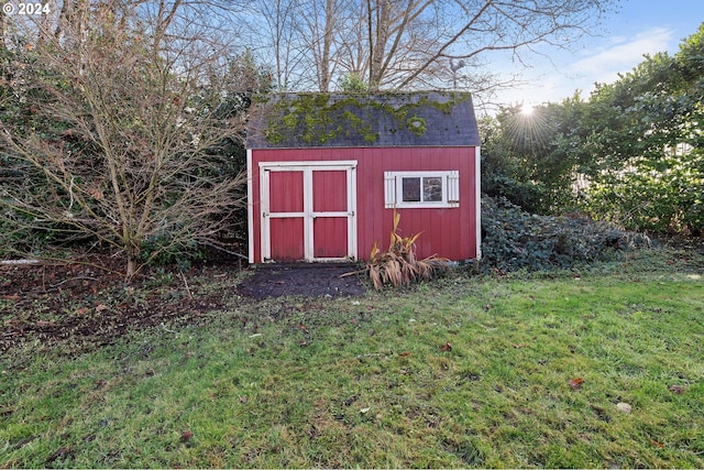 view of outdoor structure featuring a lawn