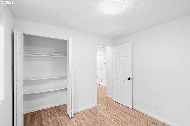 unfurnished bedroom featuring a closet and light hardwood / wood-style floors