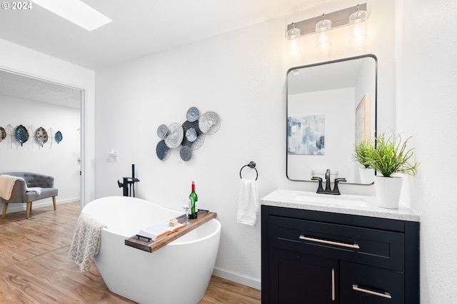 bathroom featuring a bathtub, vanity, and wood-type flooring