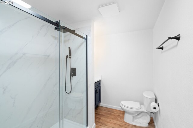 bathroom featuring hardwood / wood-style floors, vanity, toilet, and an enclosed shower