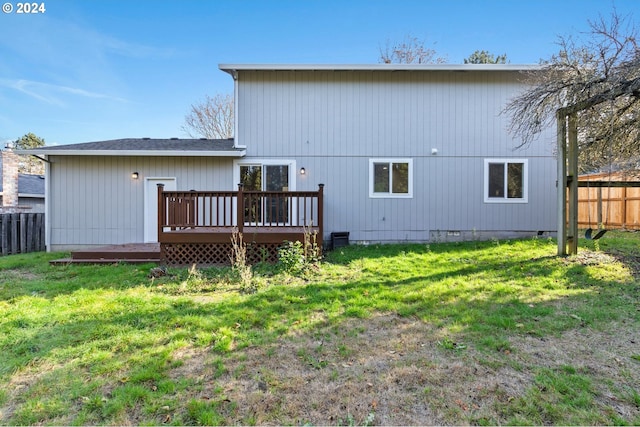 rear view of house with a deck and a yard