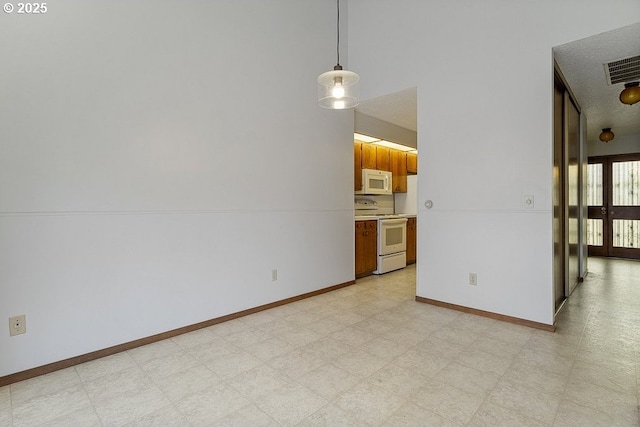 empty room featuring light floors, visible vents, and baseboards