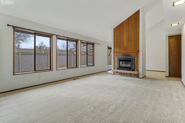 unfurnished living room with high vaulted ceiling, light carpet, a fireplace, visible vents, and baseboards