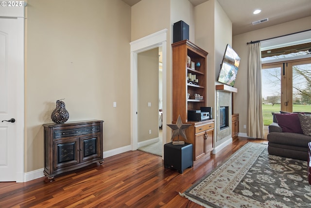 living room featuring dark wood-style floors, baseboards, and visible vents