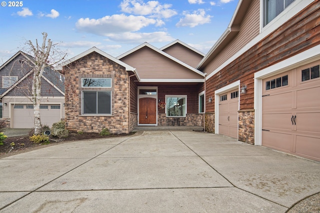 view of front facade featuring an attached garage, driveway, and stone siding