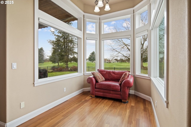 sunroom / solarium featuring a notable chandelier