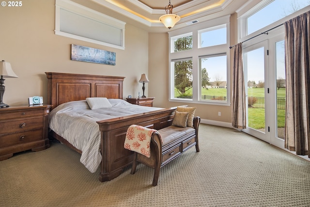 bedroom with access to exterior, a tray ceiling, visible vents, ornamental molding, and light carpet