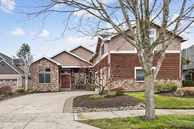 view of front facade featuring driveway and stone siding