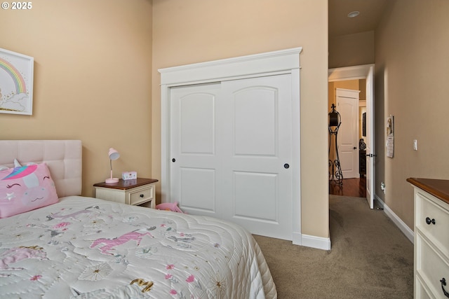 carpeted bedroom featuring baseboards and a closet