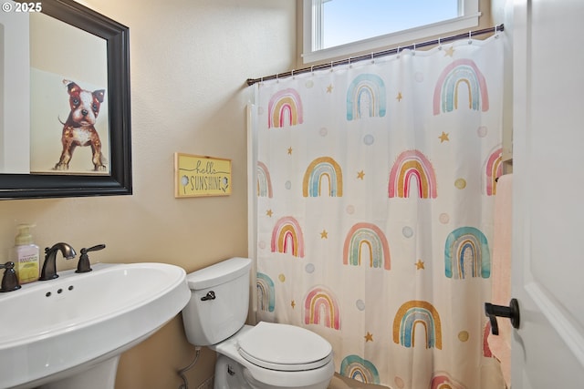 bathroom with a shower with shower curtain, a sink, and toilet