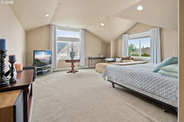 bedroom with carpet floors, multiple windows, vaulted ceiling, and a textured ceiling