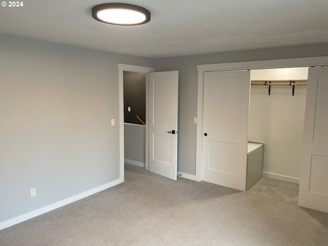 unfurnished bedroom with light carpet and a closet