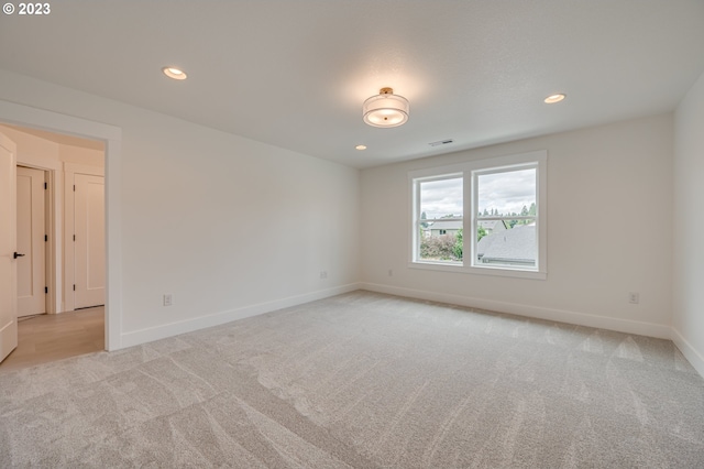 unfurnished room featuring light carpet