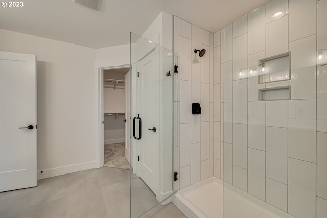 bathroom featuring tiled shower and tile patterned flooring