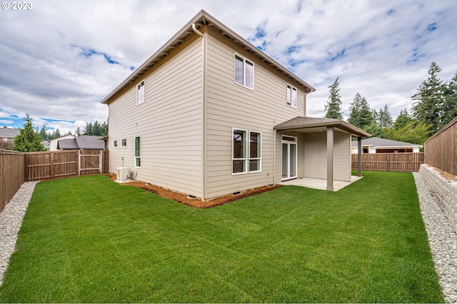 rear view of property featuring a yard, a patio, and central AC