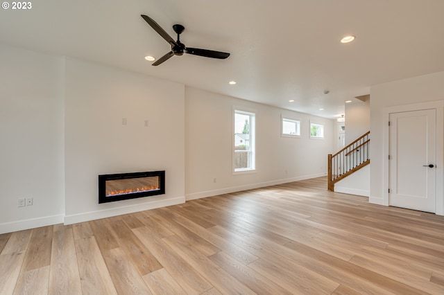 unfurnished living room featuring light wood-type flooring and ceiling fan