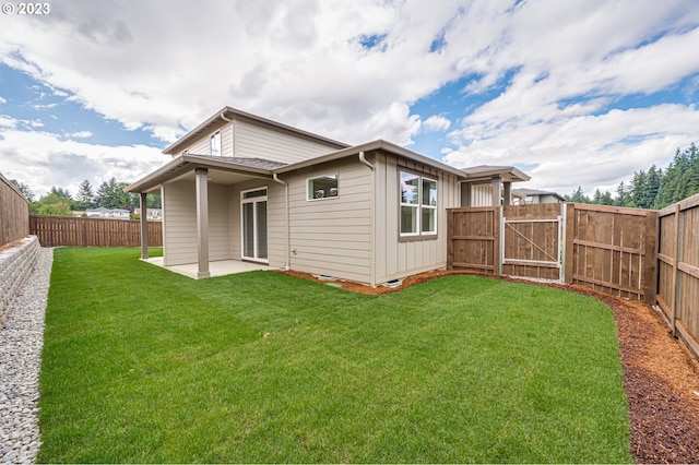 back of property featuring a lawn and a patio area