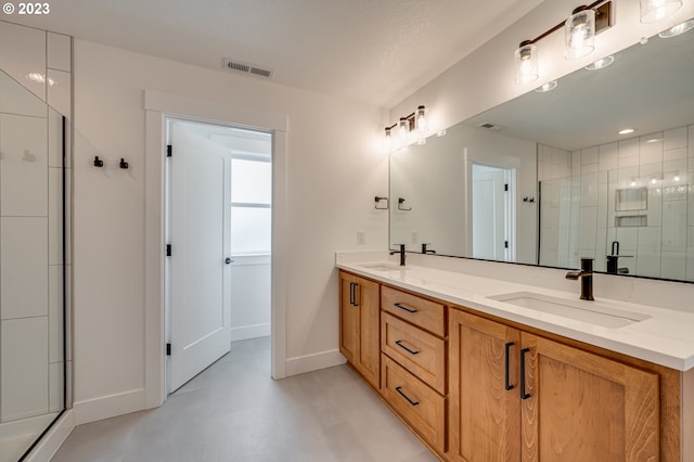 bathroom with a textured ceiling, vanity, and an enclosed shower