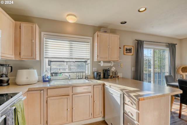 kitchen with stove, white dishwasher, light brown cabinets, sink, and kitchen peninsula