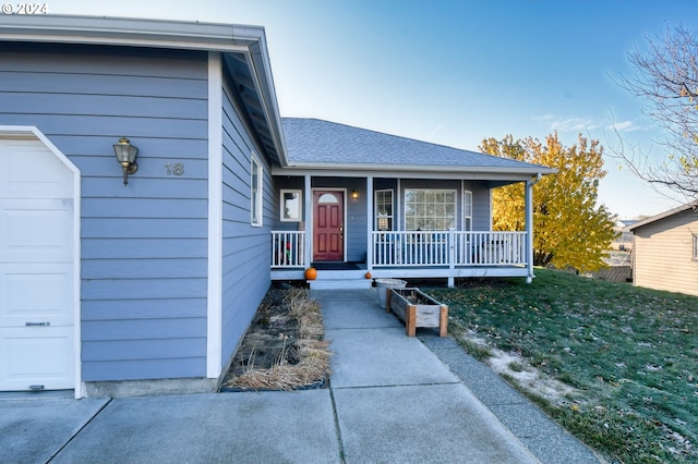 view of front of house with a garage, a front yard, and covered porch