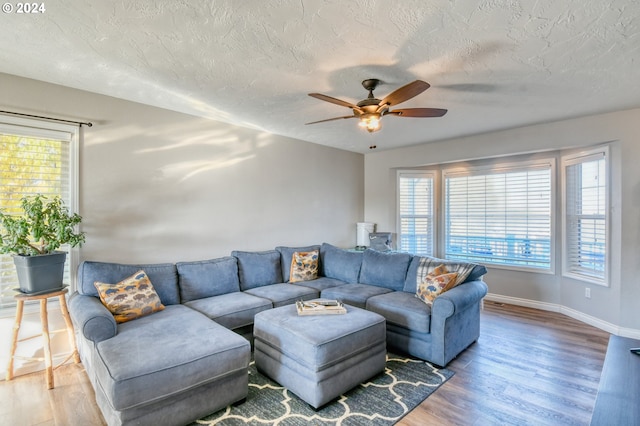 living room featuring hardwood / wood-style floors, ceiling fan, and a textured ceiling