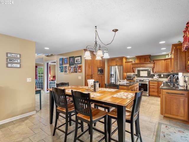 dining room featuring a textured ceiling, sink, and a notable chandelier