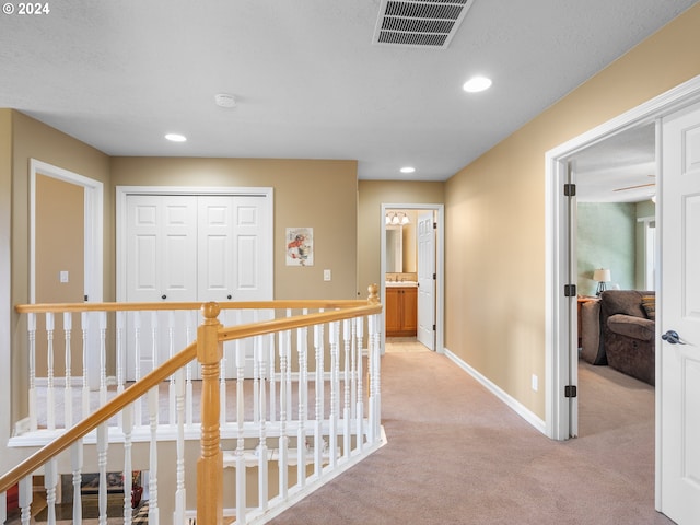 hall featuring light colored carpet