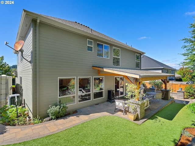 rear view of property with a lawn, central AC unit, outdoor lounge area, and a patio