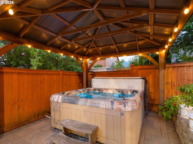 view of patio / terrace with a hot tub and a gazebo