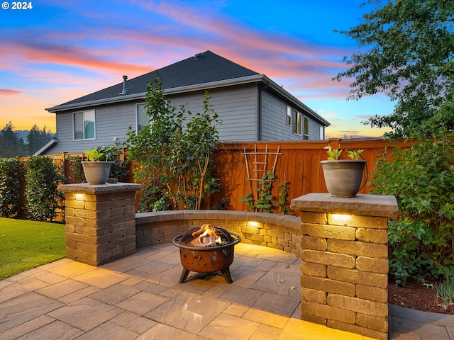 patio terrace at dusk featuring an outdoor fire pit