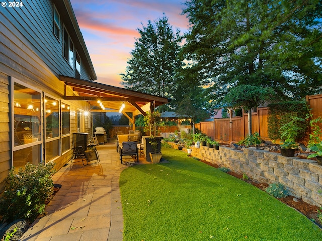 yard at dusk featuring a patio