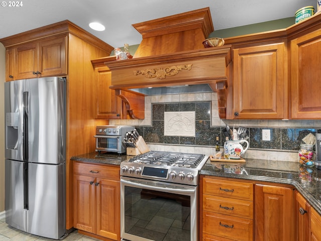 kitchen featuring dark stone countertops, appliances with stainless steel finishes, custom range hood, and tasteful backsplash