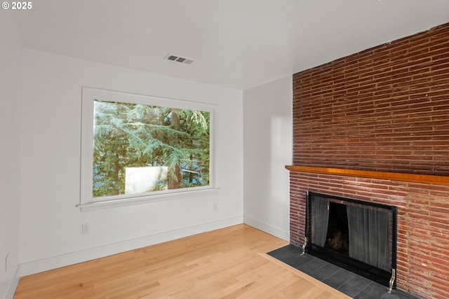 unfurnished living room featuring a fireplace and wood-type flooring