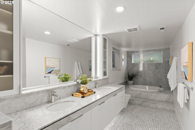 bathroom featuring vanity, tiled tub, and tile patterned floors