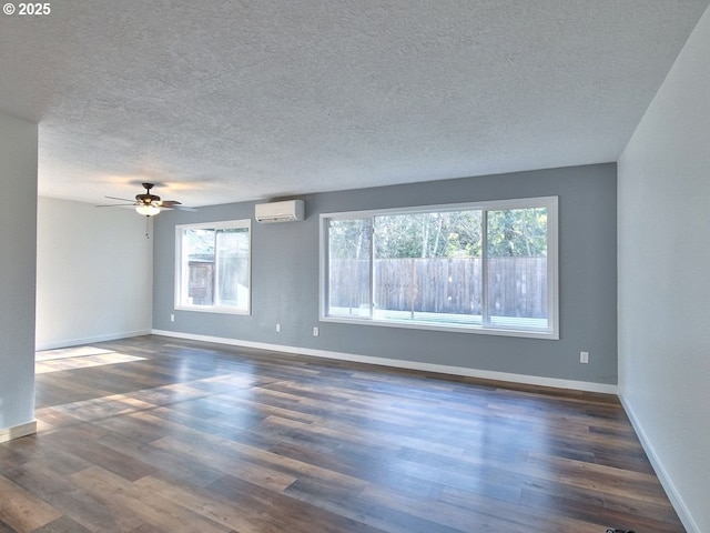 empty room with an AC wall unit, dark wood-type flooring, a healthy amount of sunlight, and ceiling fan