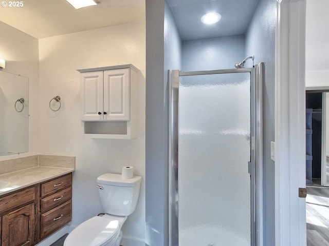 bathroom featuring toilet, walk in shower, and vanity