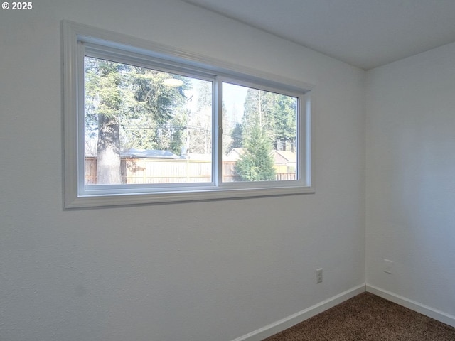 spare room featuring dark carpet