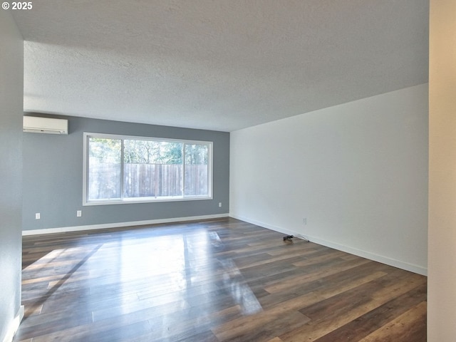 empty room with an AC wall unit, a textured ceiling, and dark hardwood / wood-style flooring