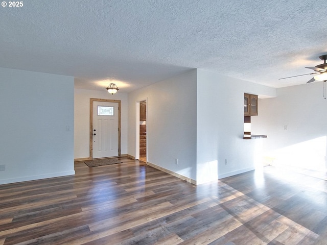 foyer entrance featuring ceiling fan, a textured ceiling, and dark hardwood / wood-style floors