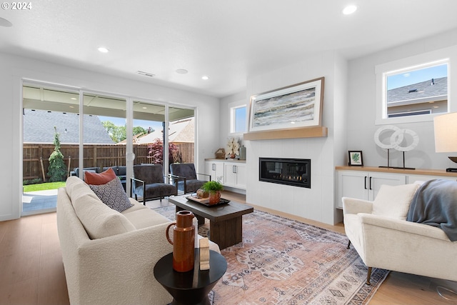 living room featuring light hardwood / wood-style flooring and a tile fireplace