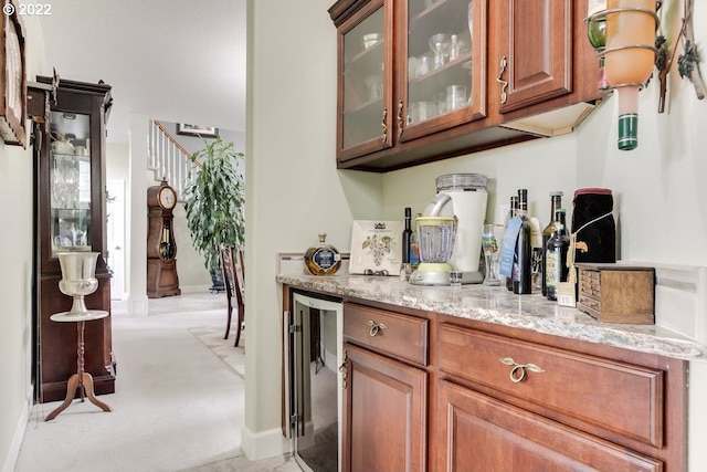 bar with light stone countertops and beverage cooler