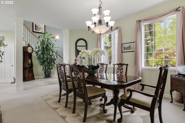 carpeted dining area with an inviting chandelier